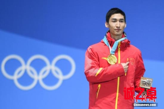 图为武大靖在获颁金牌后手指胸前五星红旗。中新社记者 崔楠 摄