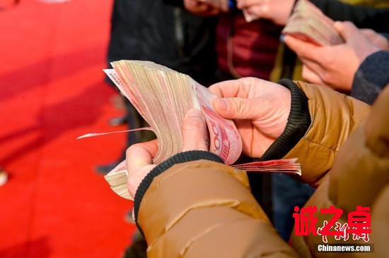 图为农民工正在清点工资。来源:视觉中国